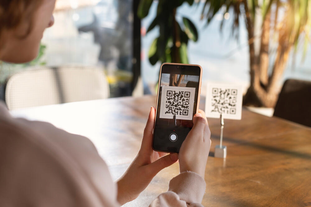 A women scanning a QR code off a paper holder in a outdoor setting